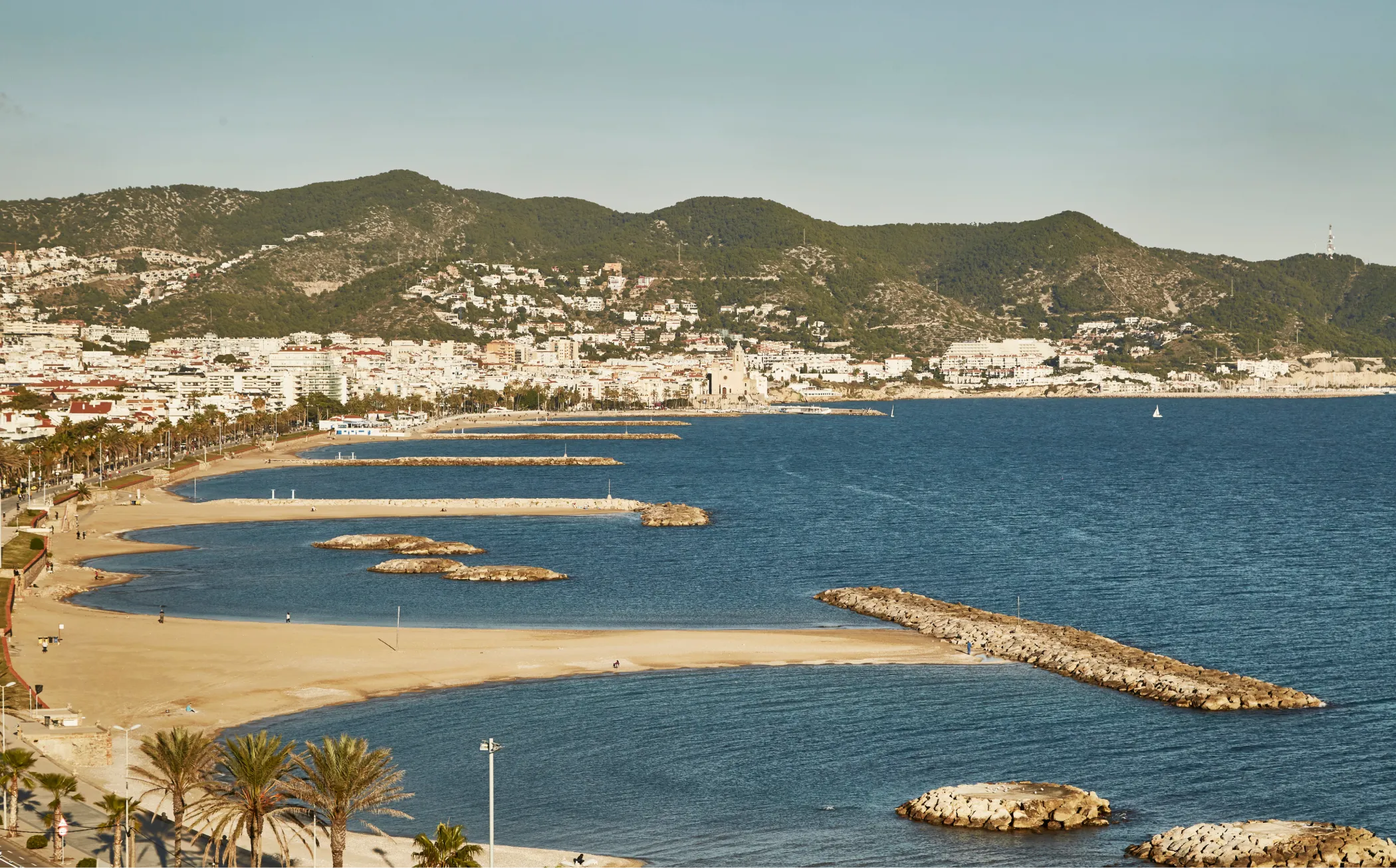 Panoramic view of Sitges beaches from the sea with the Garraf mountain range in the background.