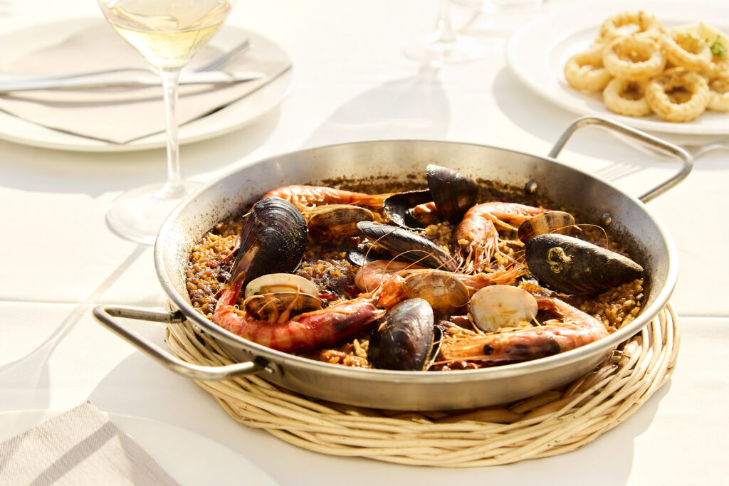 Paella de marisc amb gambes, musclos i cloïsses en un restaurant de Sitges