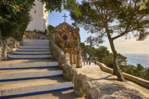 Ermita de la Trinitat de Sitges amb escales, vegetació mediterrània i vistes al mar