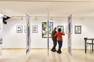 Parella visitant una exposició d’art en una galeria de Sitges.