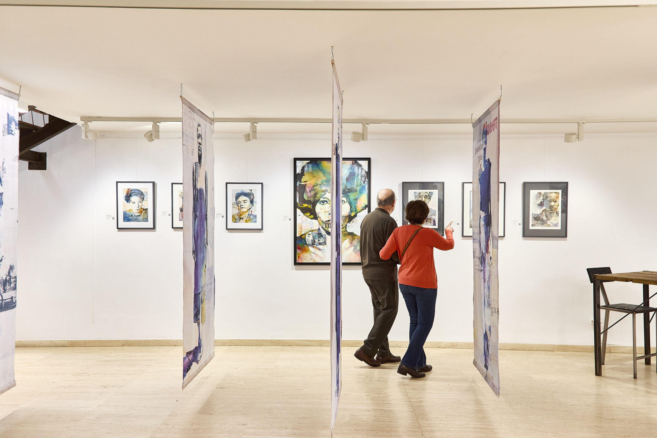 Parella visitant una exposició d’art en una galeria de Sitges.
